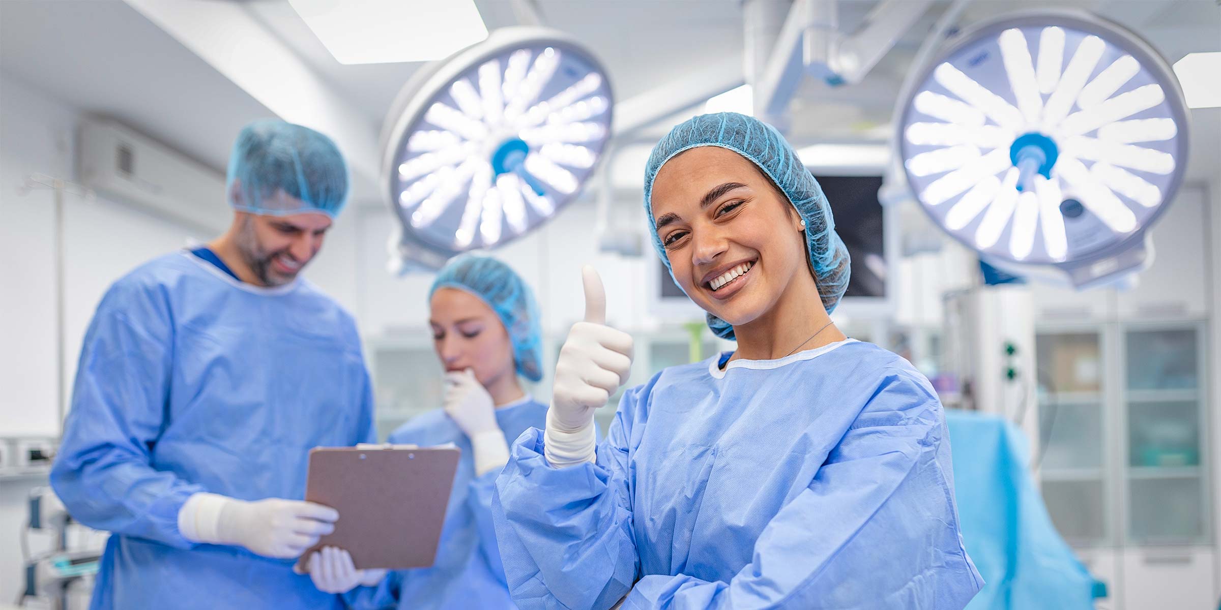Smiling medical professional giving thumbs up in operating room, representing high-quality protective medical gear from AHP